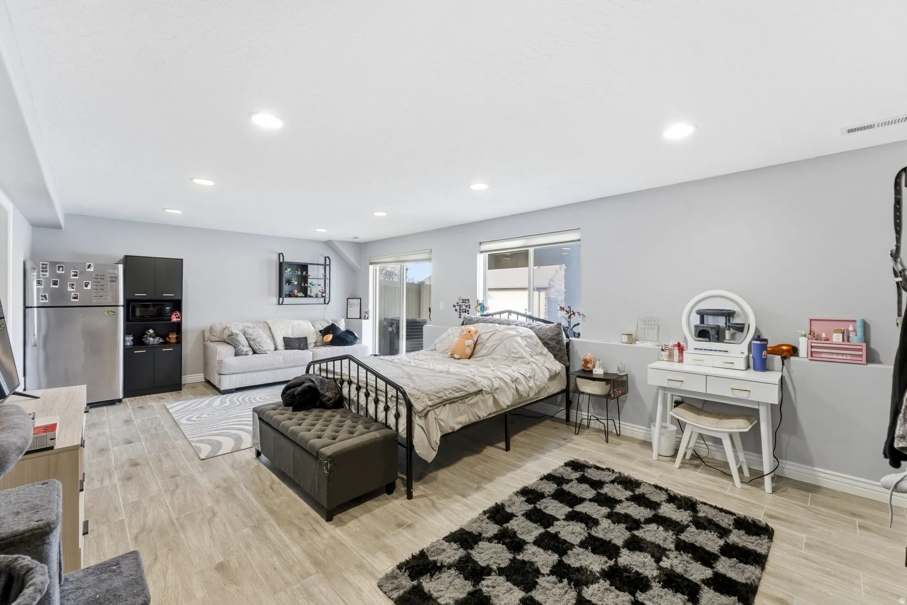 Bedroom with freestanding refrigerator, wood finish floors, and recessed lighting