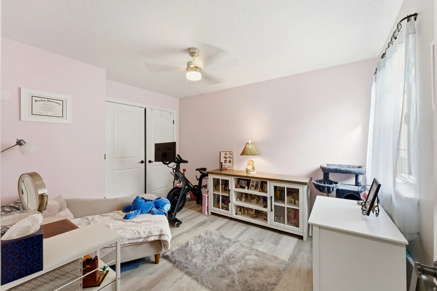 Bedroom featuring light wood finished floors, a ceiling fan, and a closet