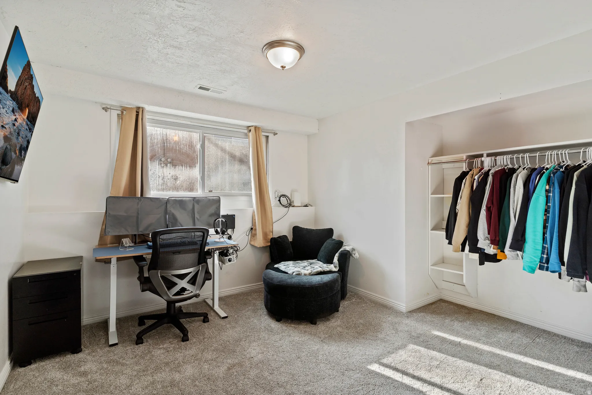 Home office featuring light carpet and a textured ceiling