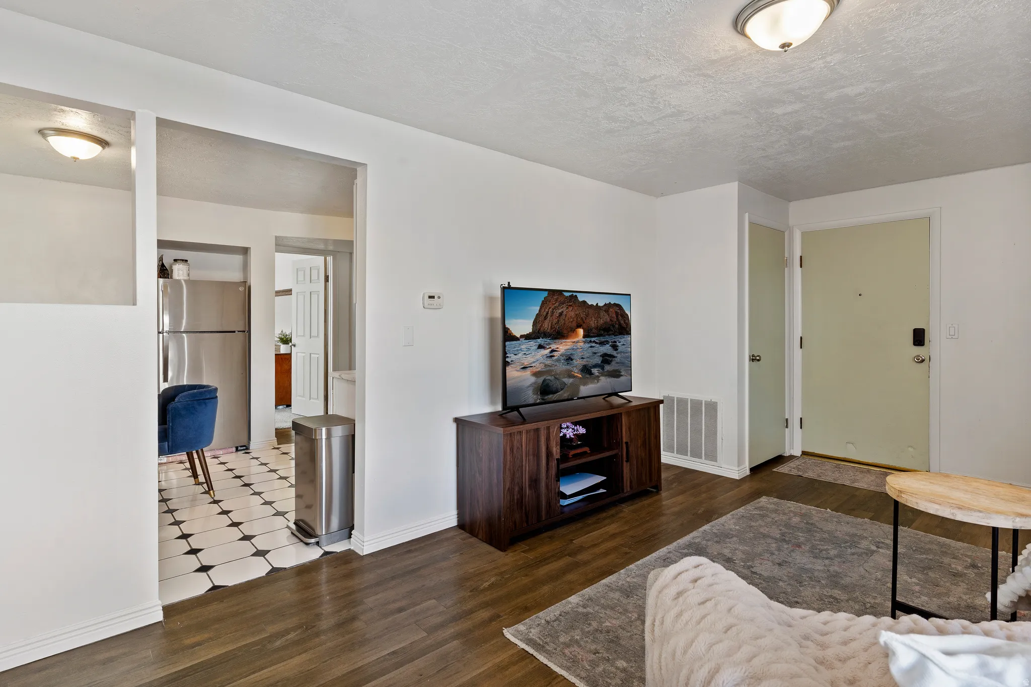 Living area featuring dark wood finished floors and a textured ceiling