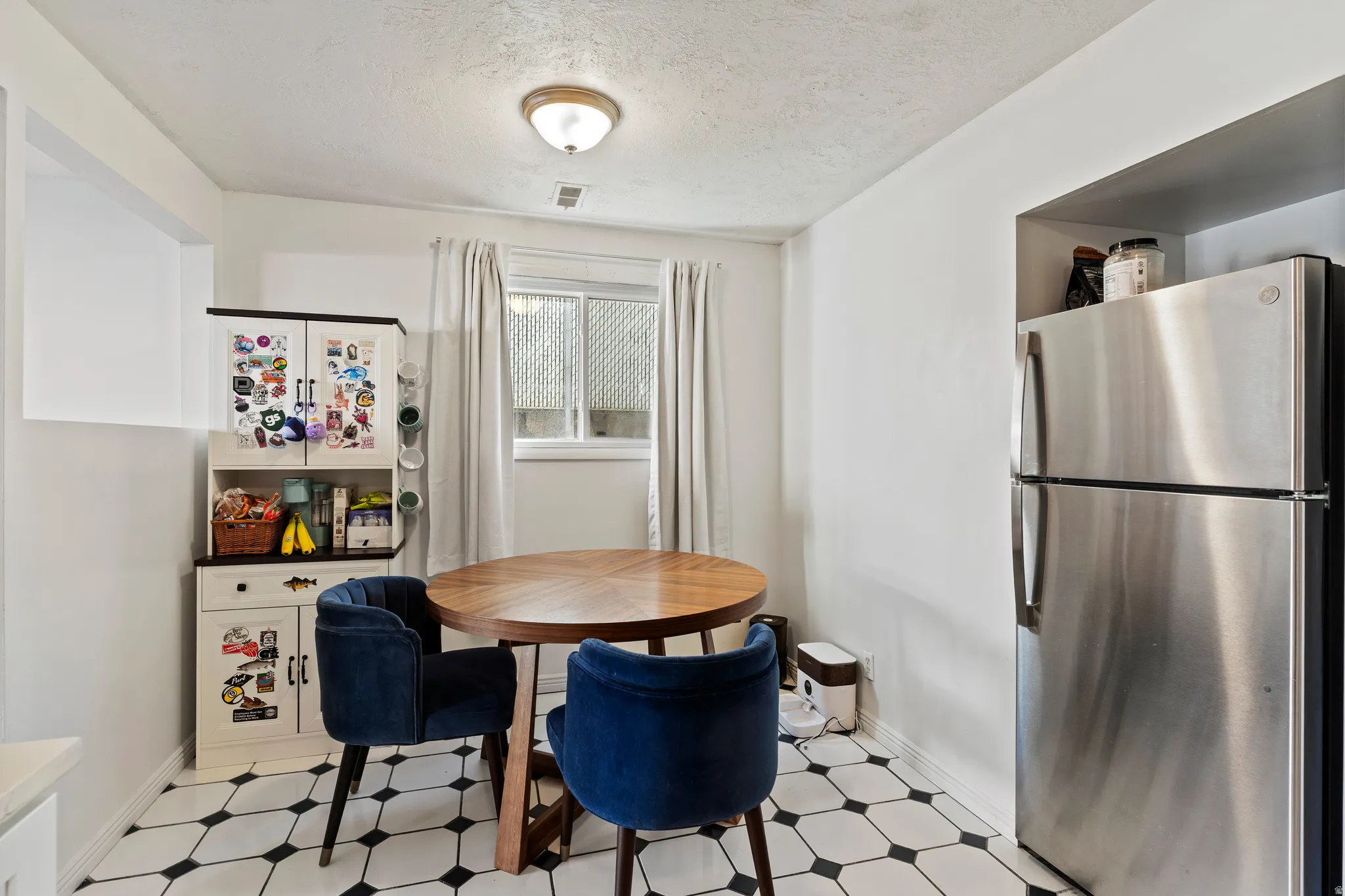Dining room with light flooring and a textured ceiling
