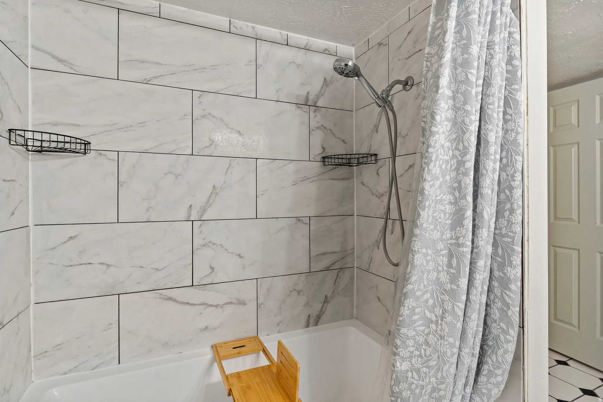 Bathroom with shower / tub combo and a textured ceiling