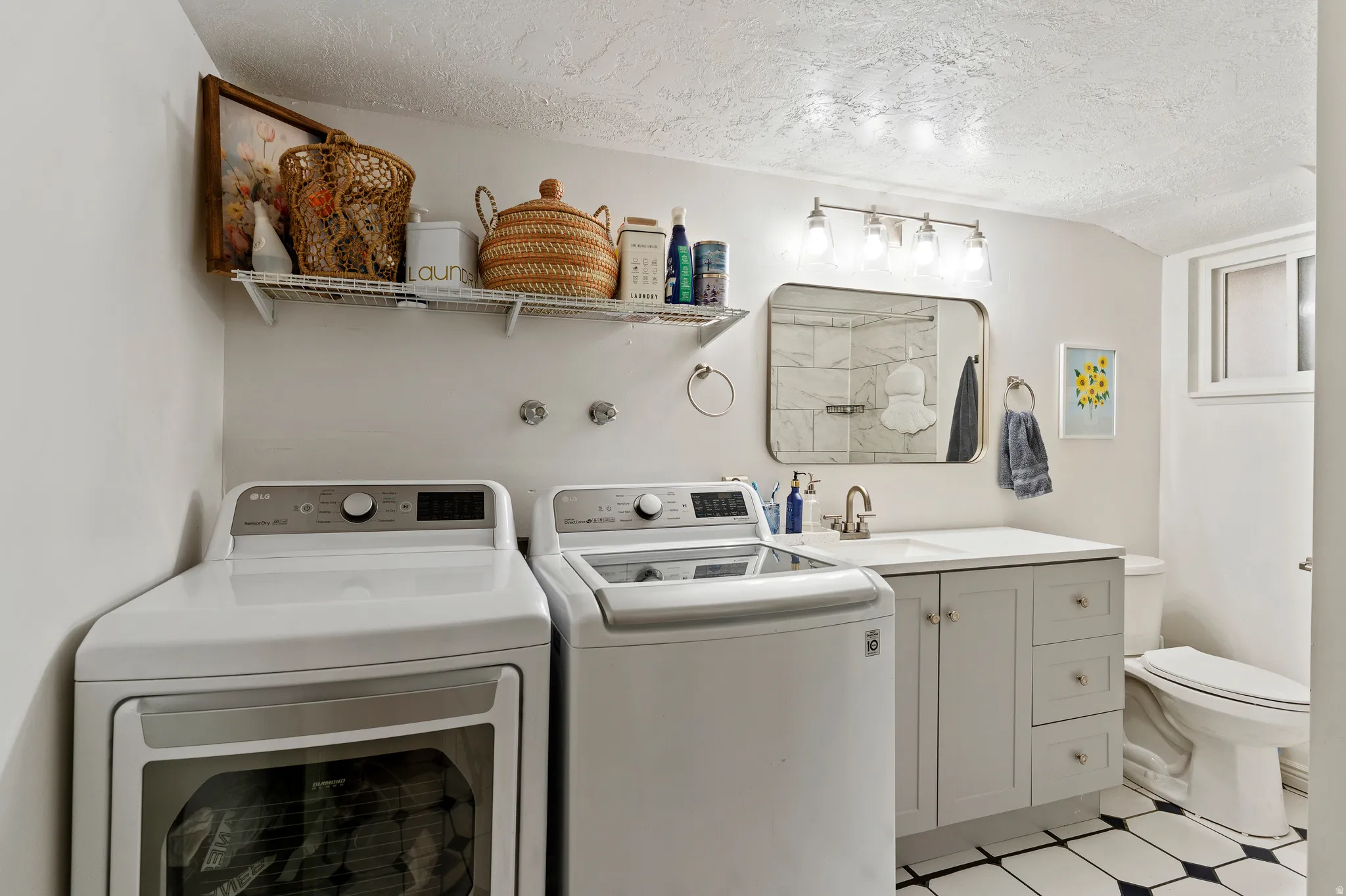 Laundry room featuring a textured ceiling, washer and clothes dryer, and vaulted ceiling