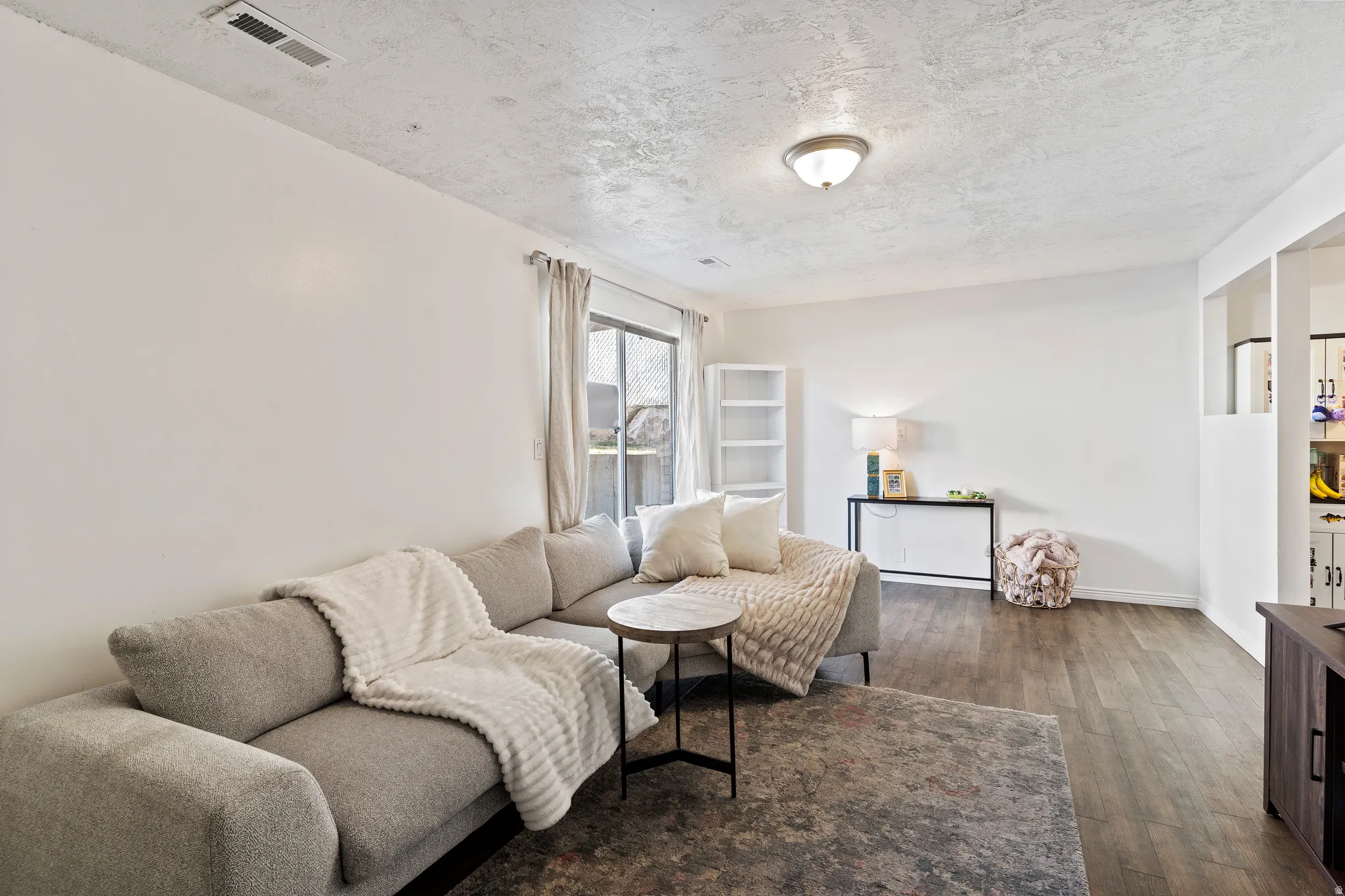 Living area with wood finished floors and a textured ceiling