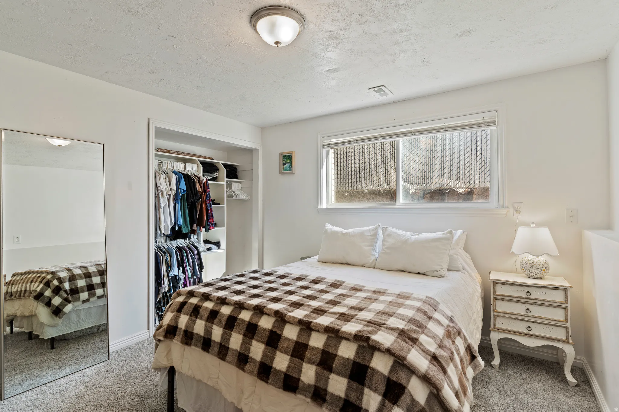 Bedroom with carpet floors, a closet, and a textured ceiling