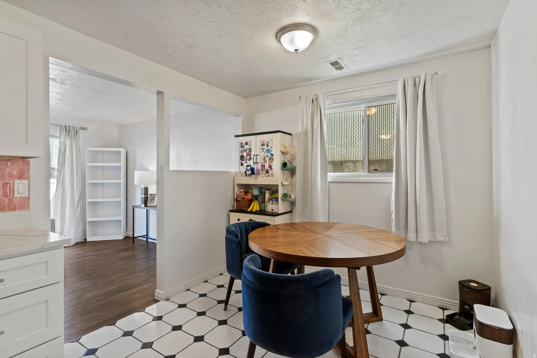 Dining space featuring dark flooring and a textured ceiling