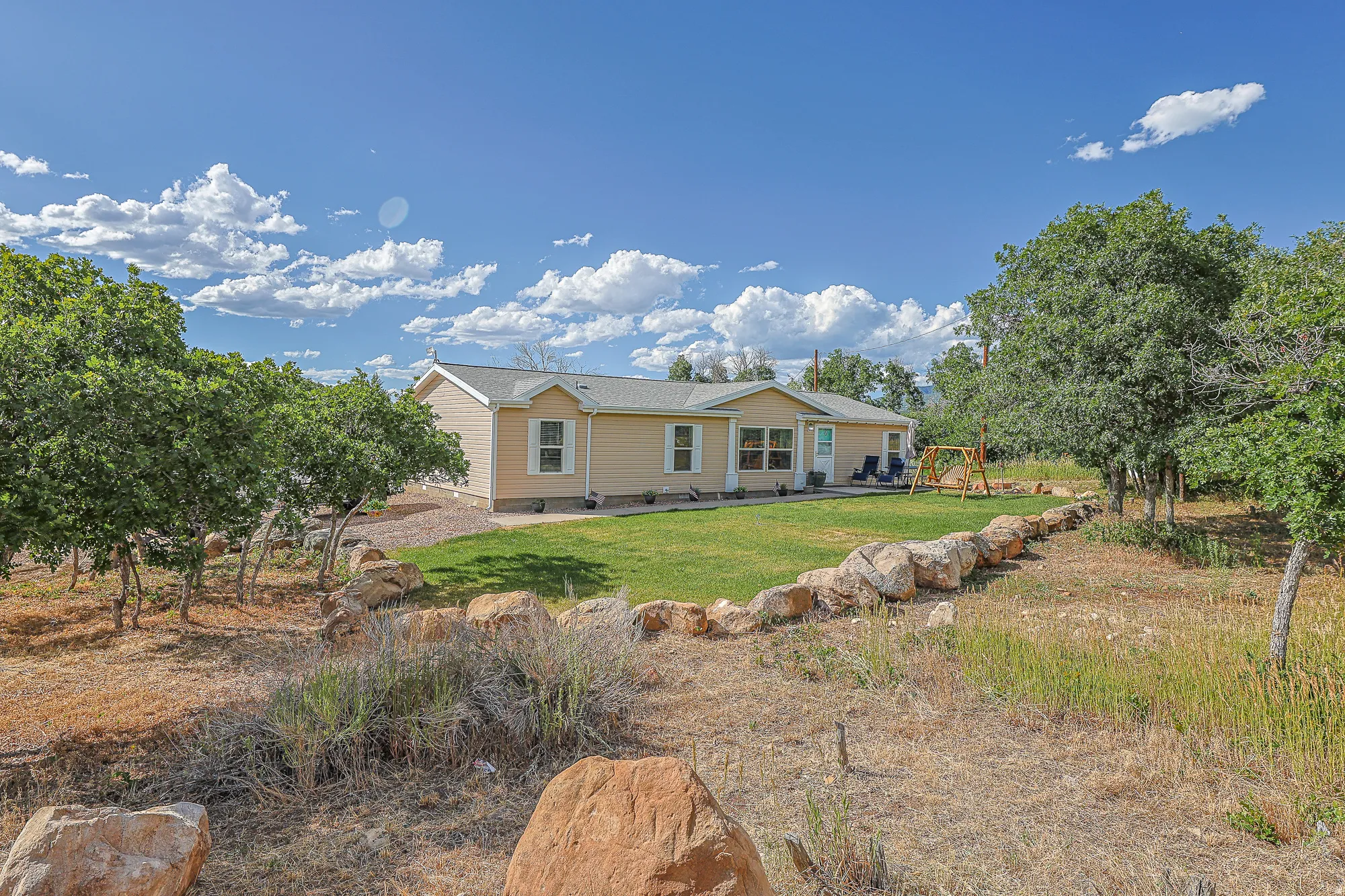 View of front of home featuring a front yard and a patio in the summer