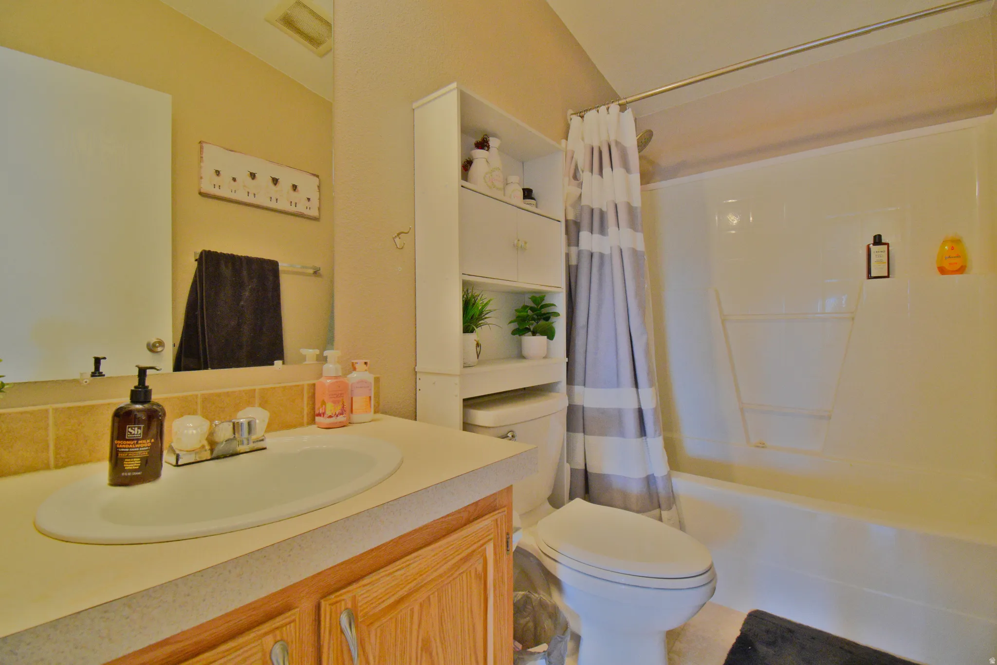 Full bathroom with shower / bath combination with curtain and vanity