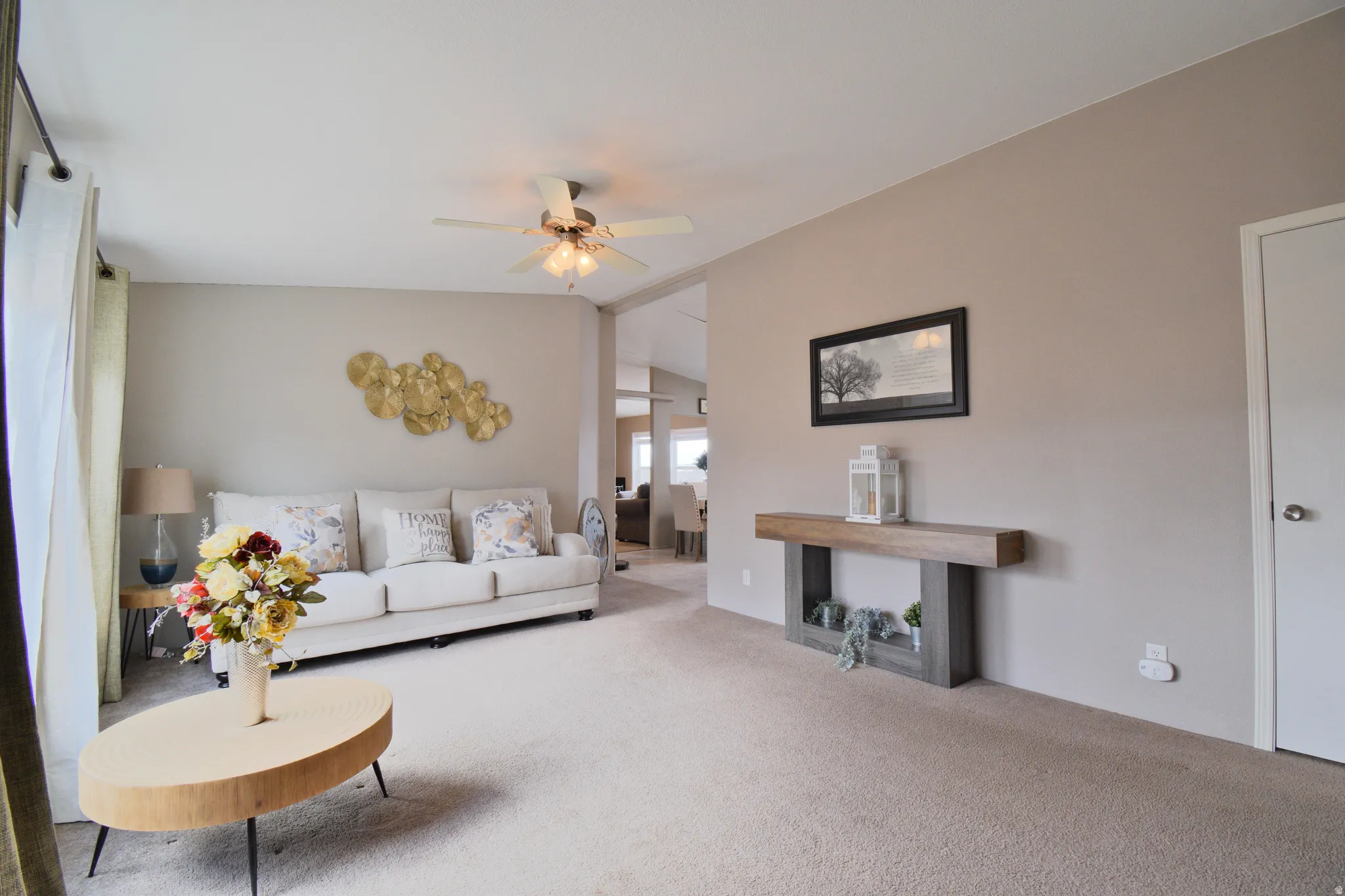 Living area featuring vaulted ceiling, carpet, and ceiling fan