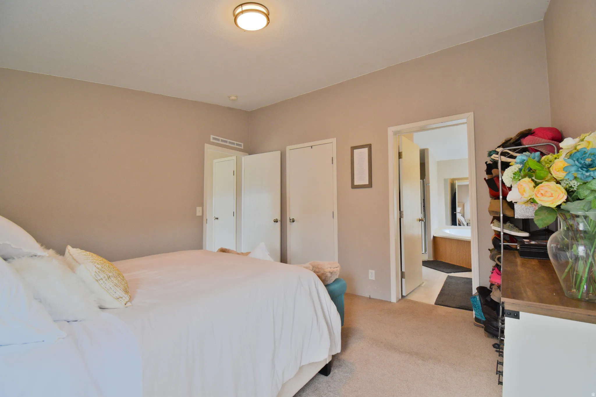 Primary Bedroom with light carpet, a closet, and connected bathroom