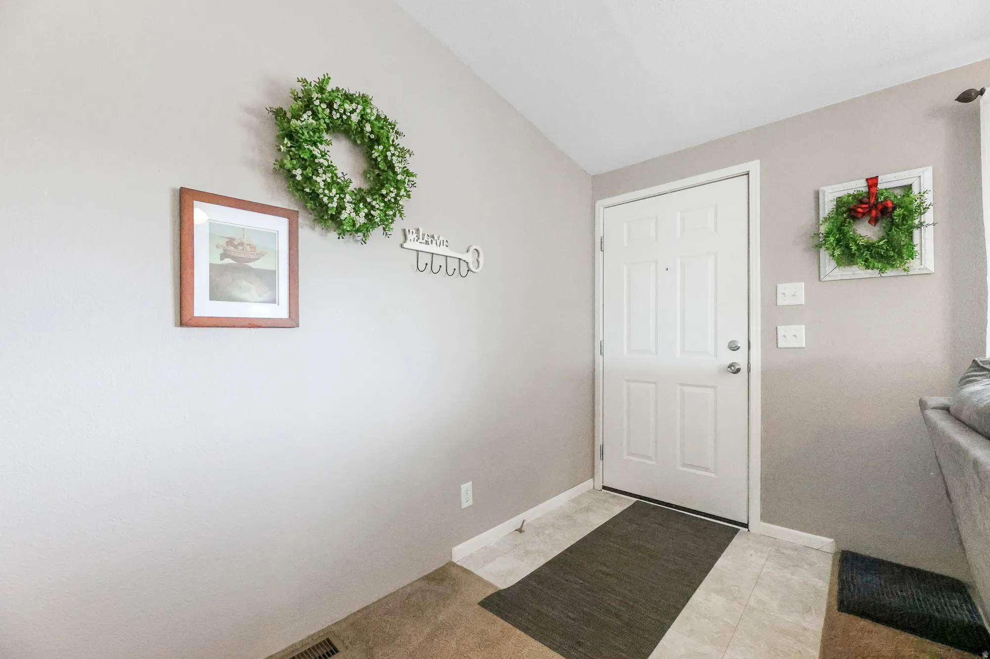 Foyer featuring vaulted ceiling and baseboards