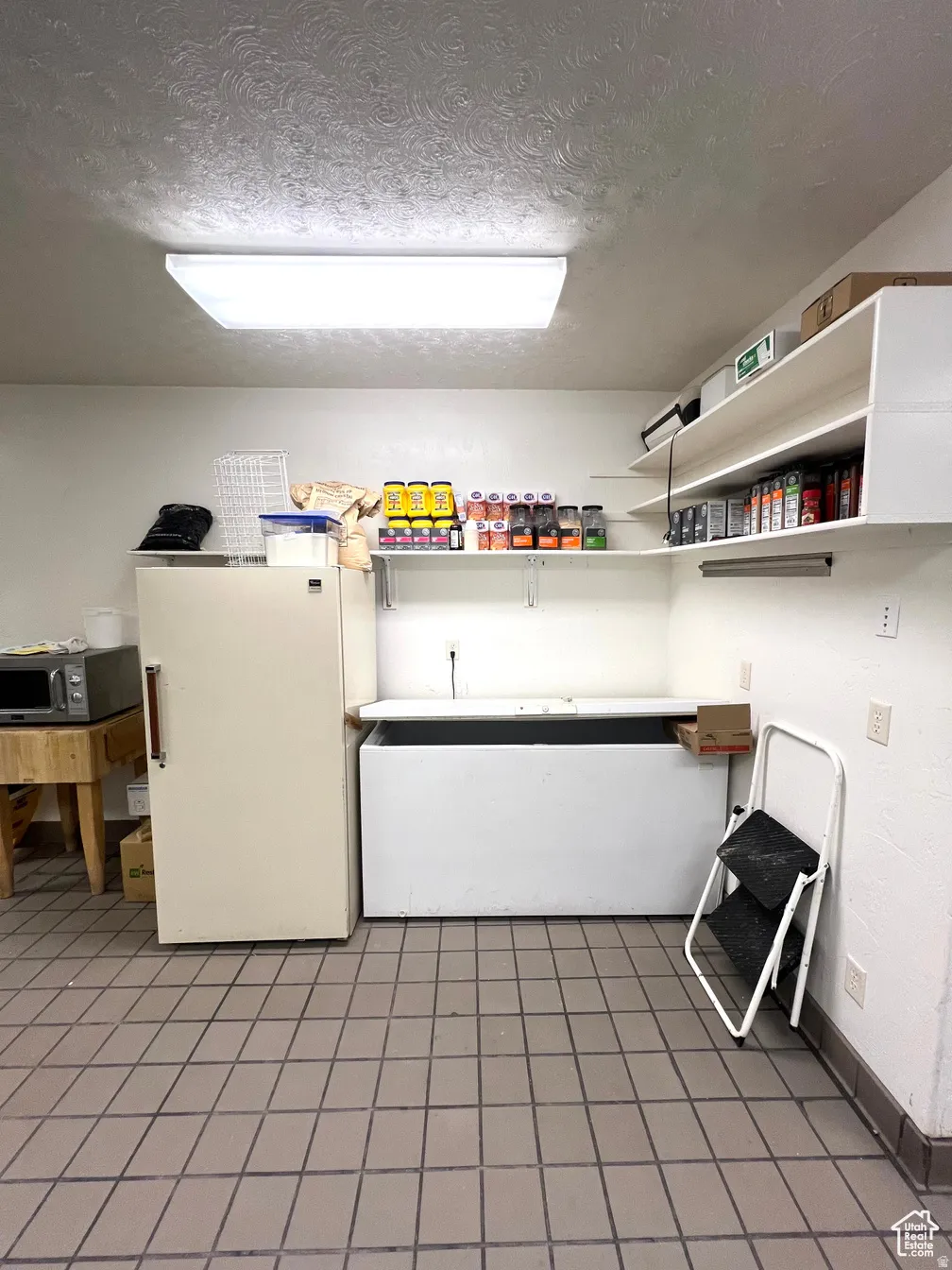 Washroom featuring a textured ceiling and baseboards