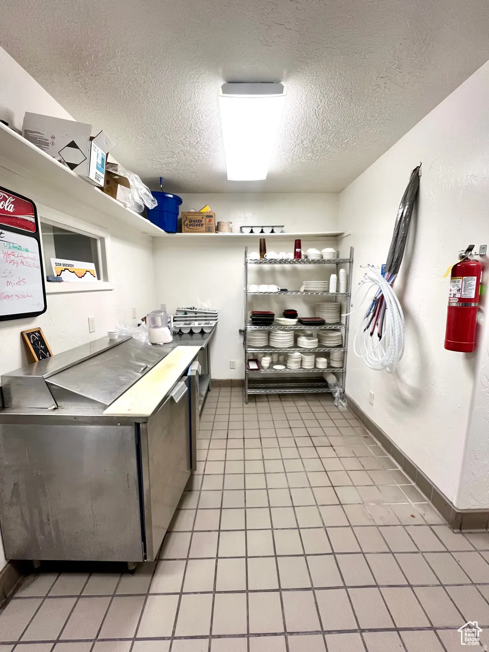 Kitchen featuring refrigerator and a textured ceiling