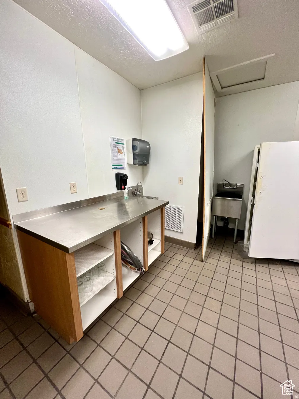 Miscellaneous room featuring attic access and a textured ceiling
