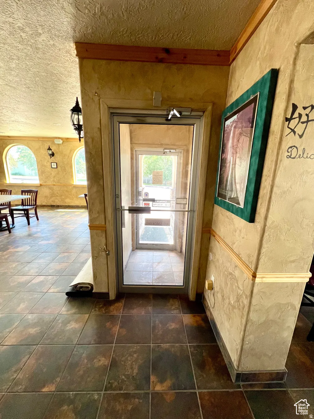 Entryway with a textured wall and a textured ceiling