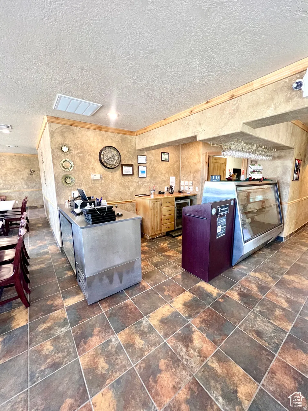 Kitchen featuring ornamental molding, beverage cooler, and a textured ceiling