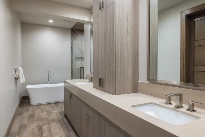 Full bath featuring double vanity, a freestanding tub, dark wood-type flooring, recessed lighting, and a shower stall