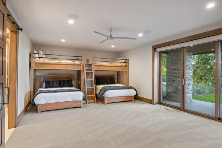 Bedroom with access to exterior, ceiling fan, light colored carpet, a barn door, and recessed lighting