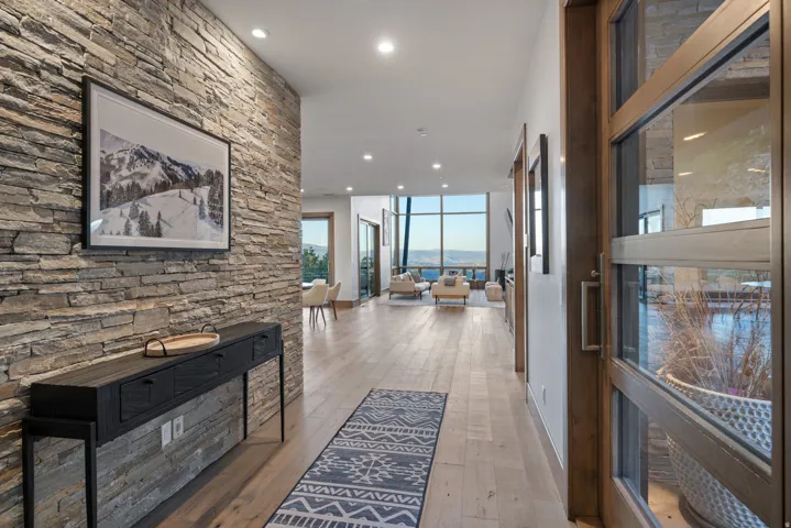 Corridor featuring recessed lighting, light wood-style flooring, and floor to ceiling windows