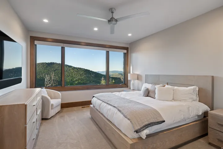 Bedroom featuring light colored carpet, a mountain view, ceiling fan, and recessed lighting