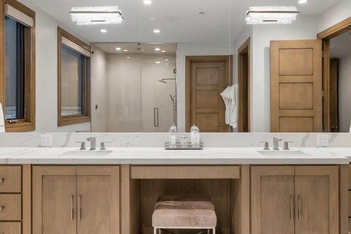 Bathroom featuring a shower stall, double vanity, and recessed lighting