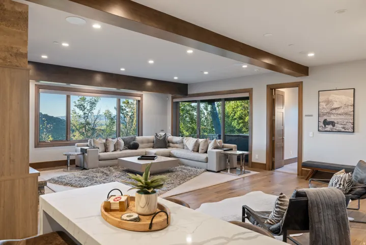 Living area with beamed ceiling, wood-type flooring, and recessed lighting