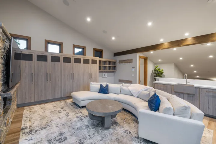 Living area with light wood finished floors, recessed lighting, and high vaulted ceiling