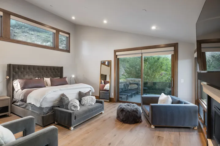 Bedroom featuring access to exterior, recessed lighting, light wood-style floors, a fireplace, and lofted ceiling