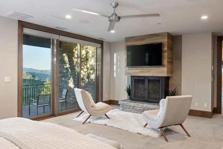 Carpeted living room with a fireplace, a ceiling fan, recessed lighting, and a mountain view