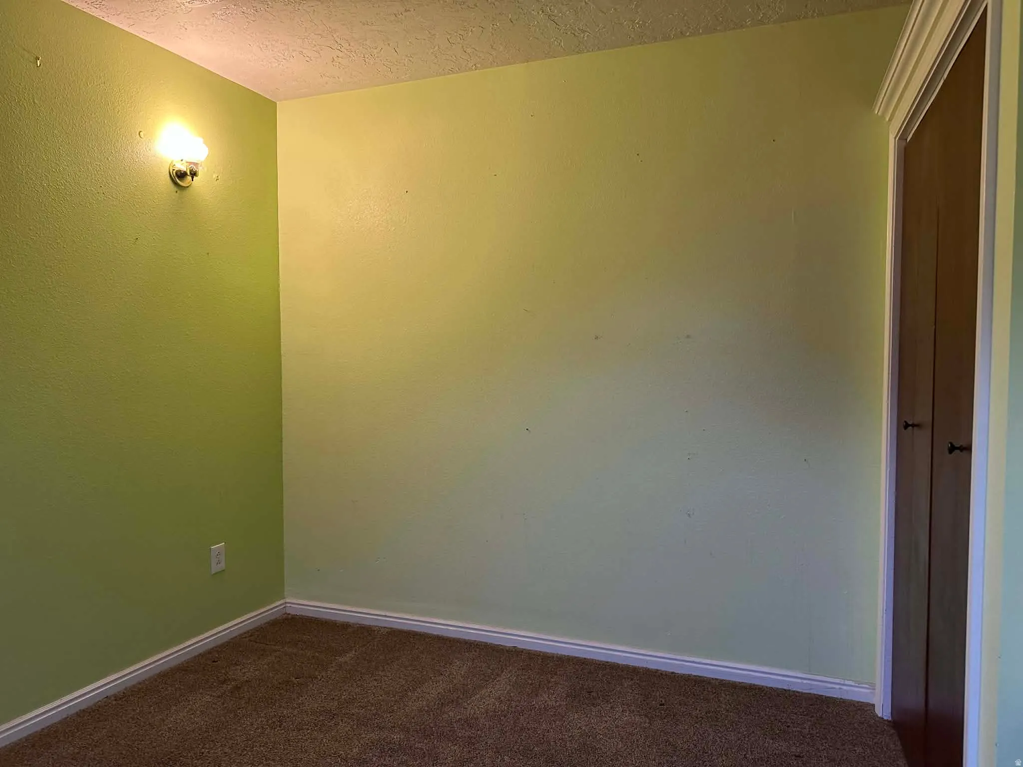 Spare room with dark colored carpet and a textured ceiling
