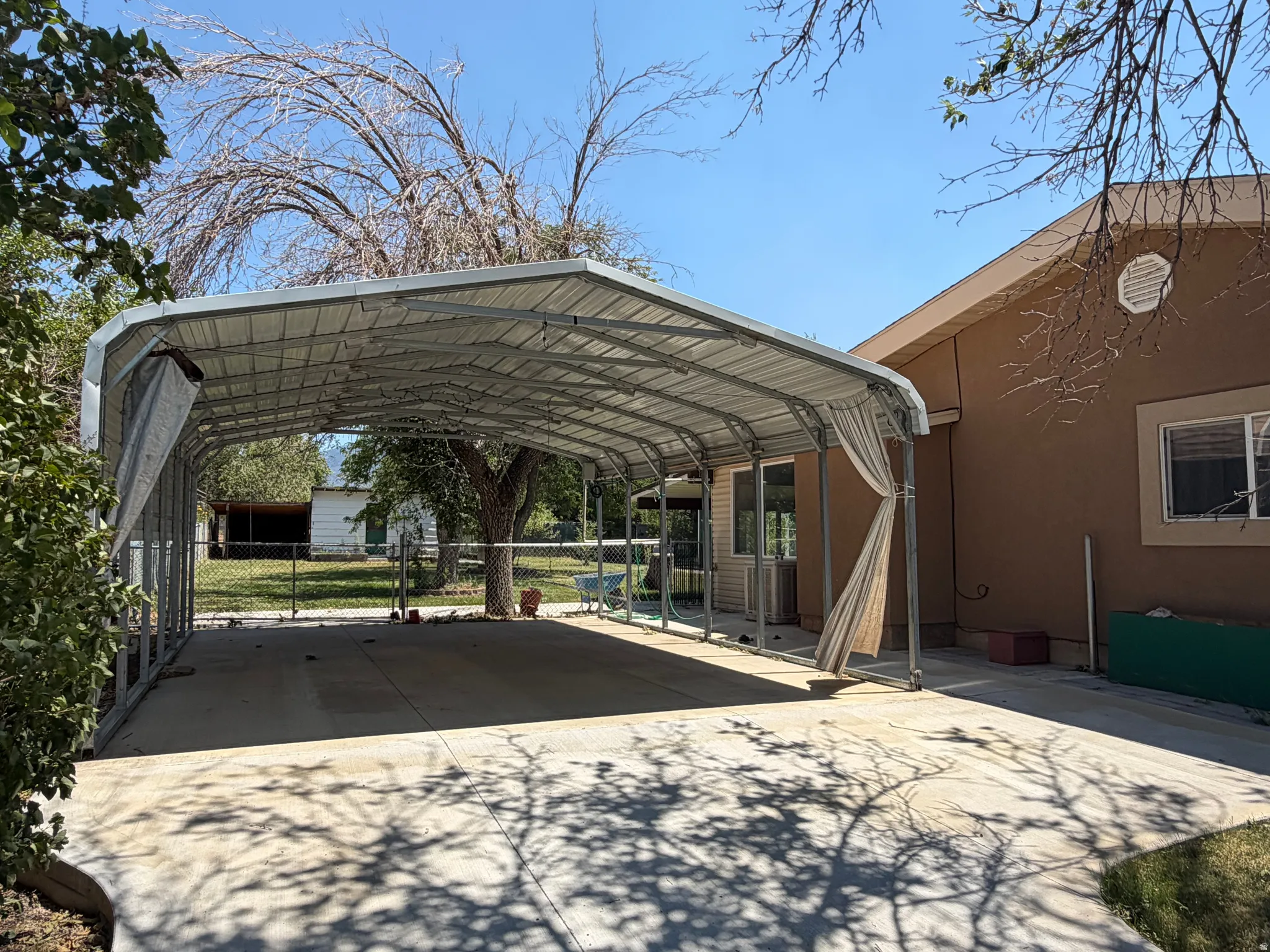 Spacious metal carport structure with a concrete pad