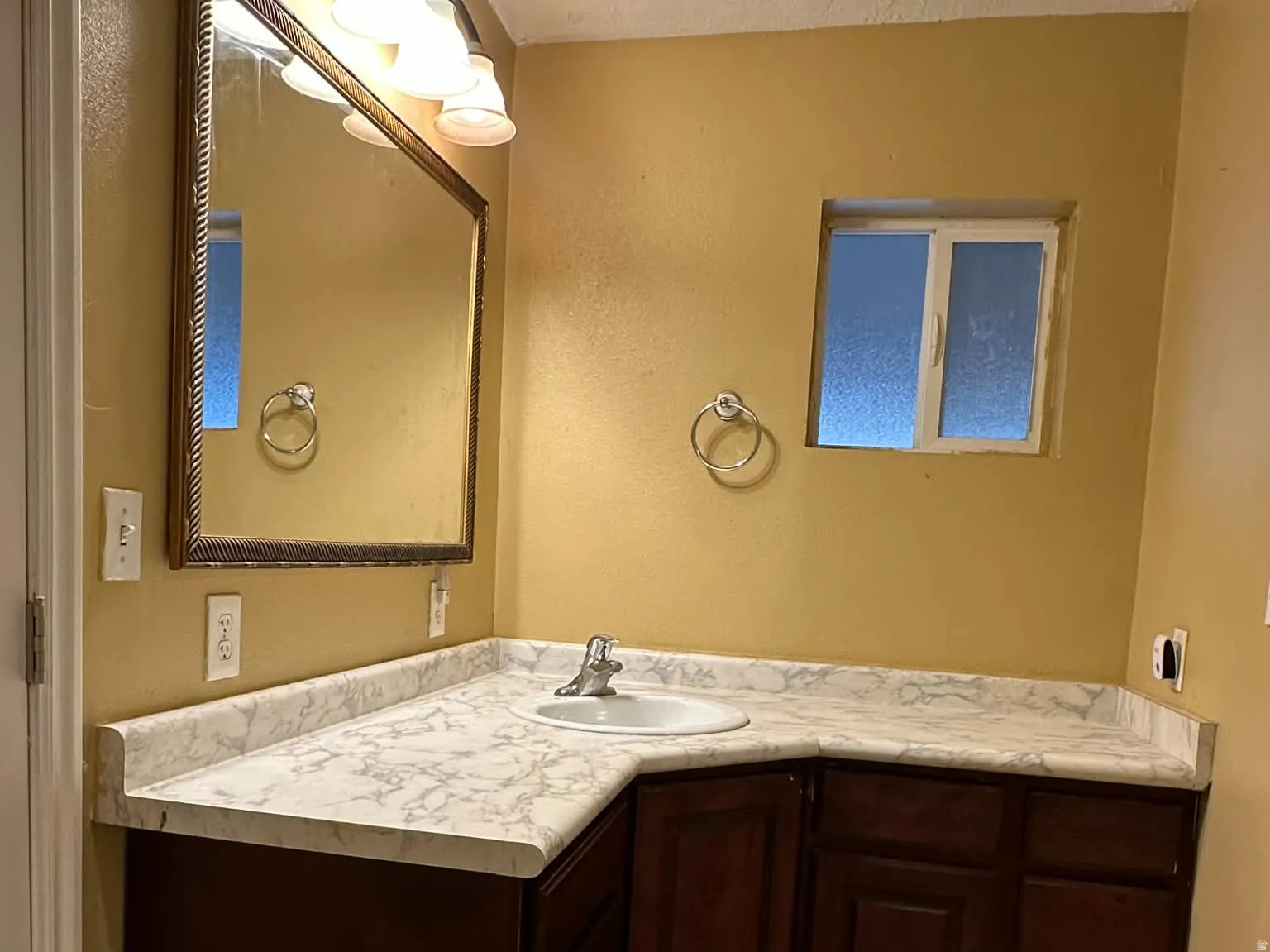 Primary bathroom with a textured ceiling, vanity, and light tile patterned flooring
