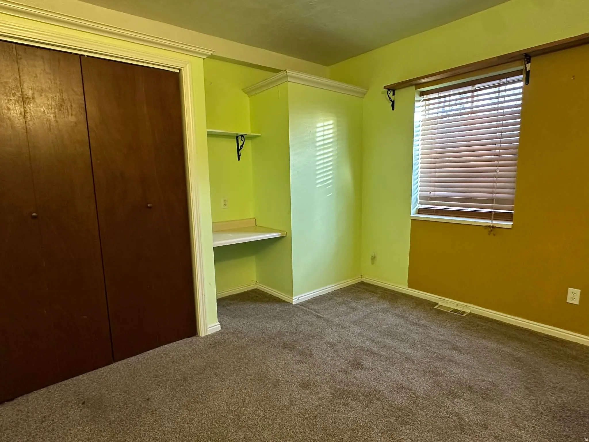 Unfurnished bedroom with dark carpet and a closet