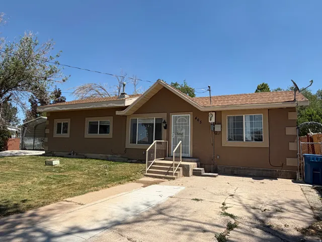 Single-story residence featuring a brown stucco exterior, brown shingle roof, and multiple windows