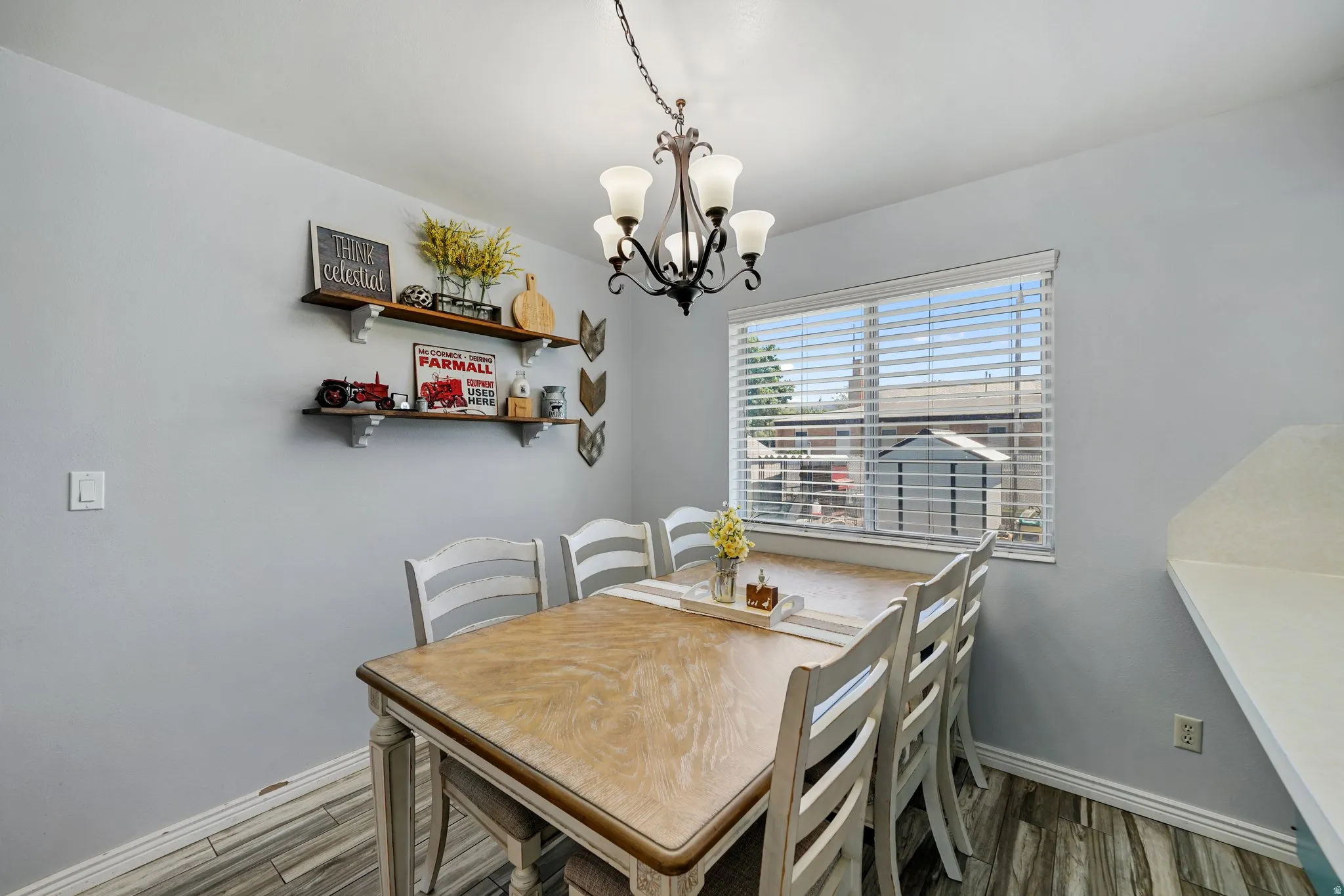 Dining space featuring dark wood-style flooring and a chandelier