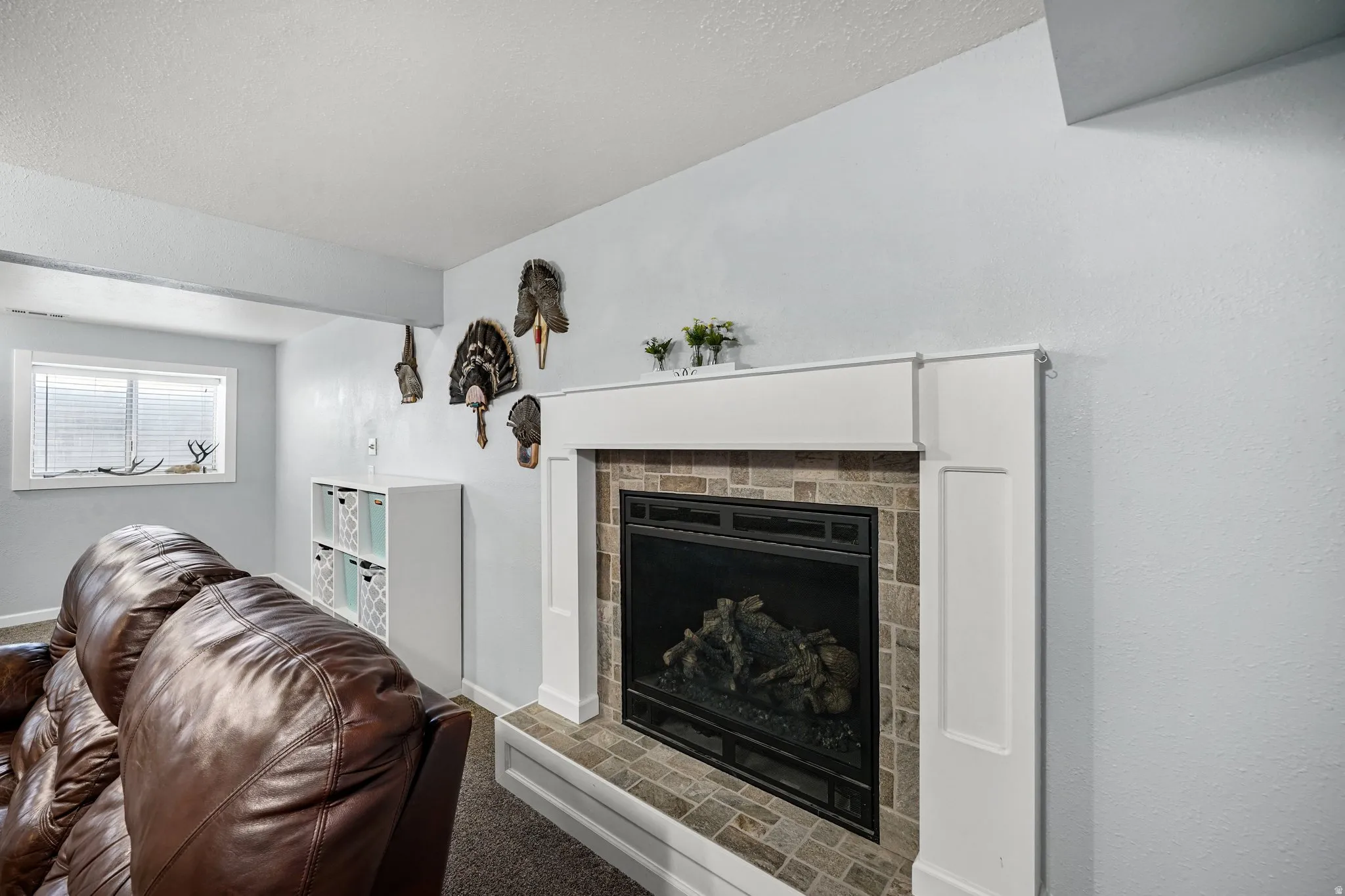 Carpeted living area with a fireplace and a textured ceiling