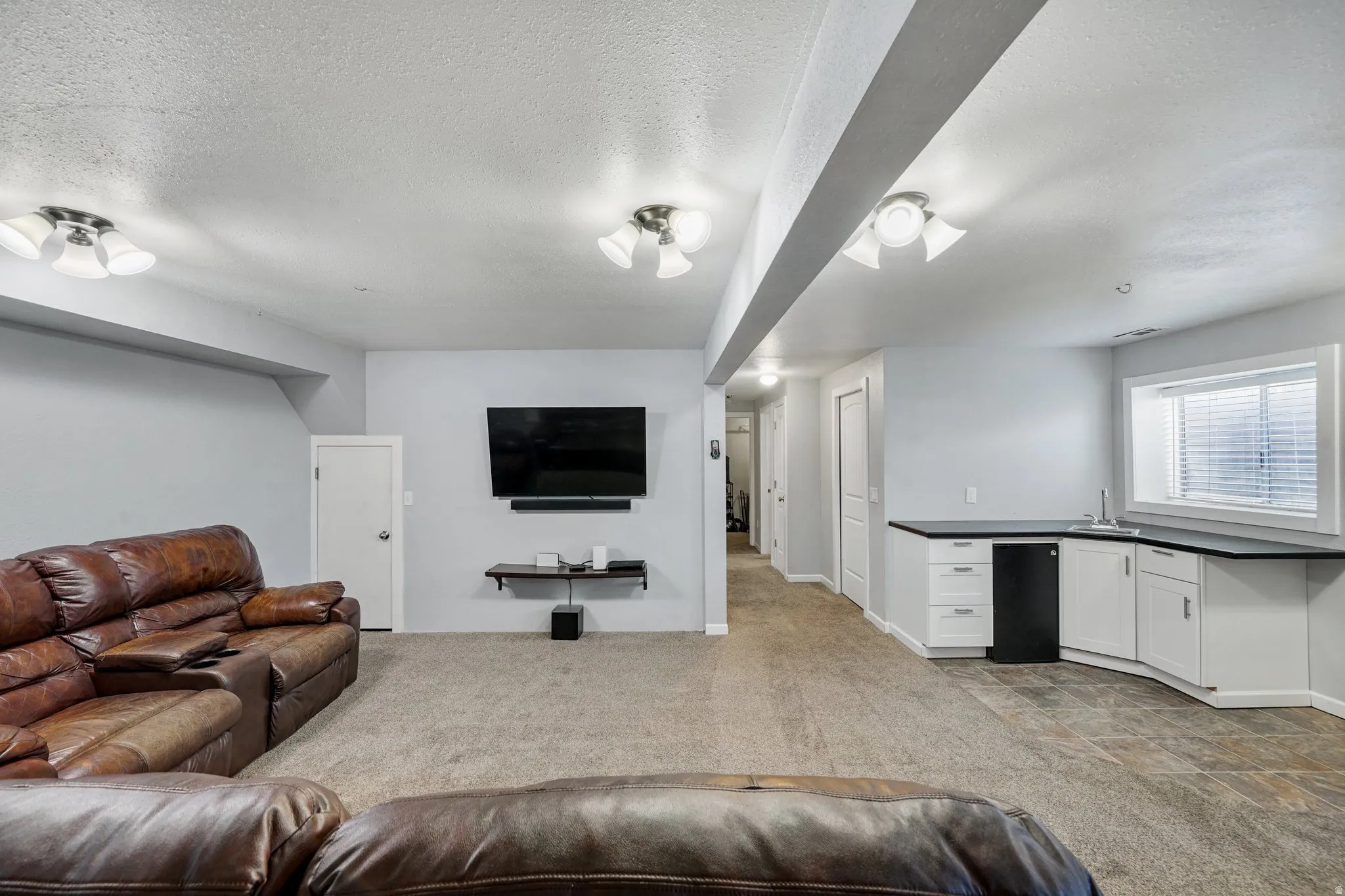Living room with light colored carpet and a textured ceiling