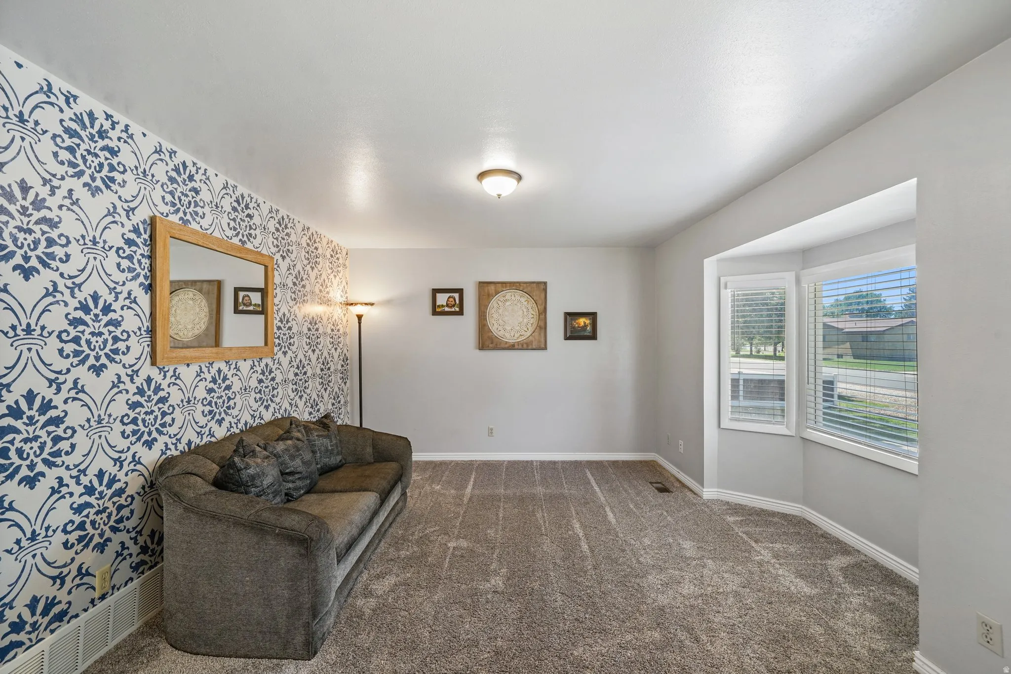 Living area with carpet and wallpapered walls