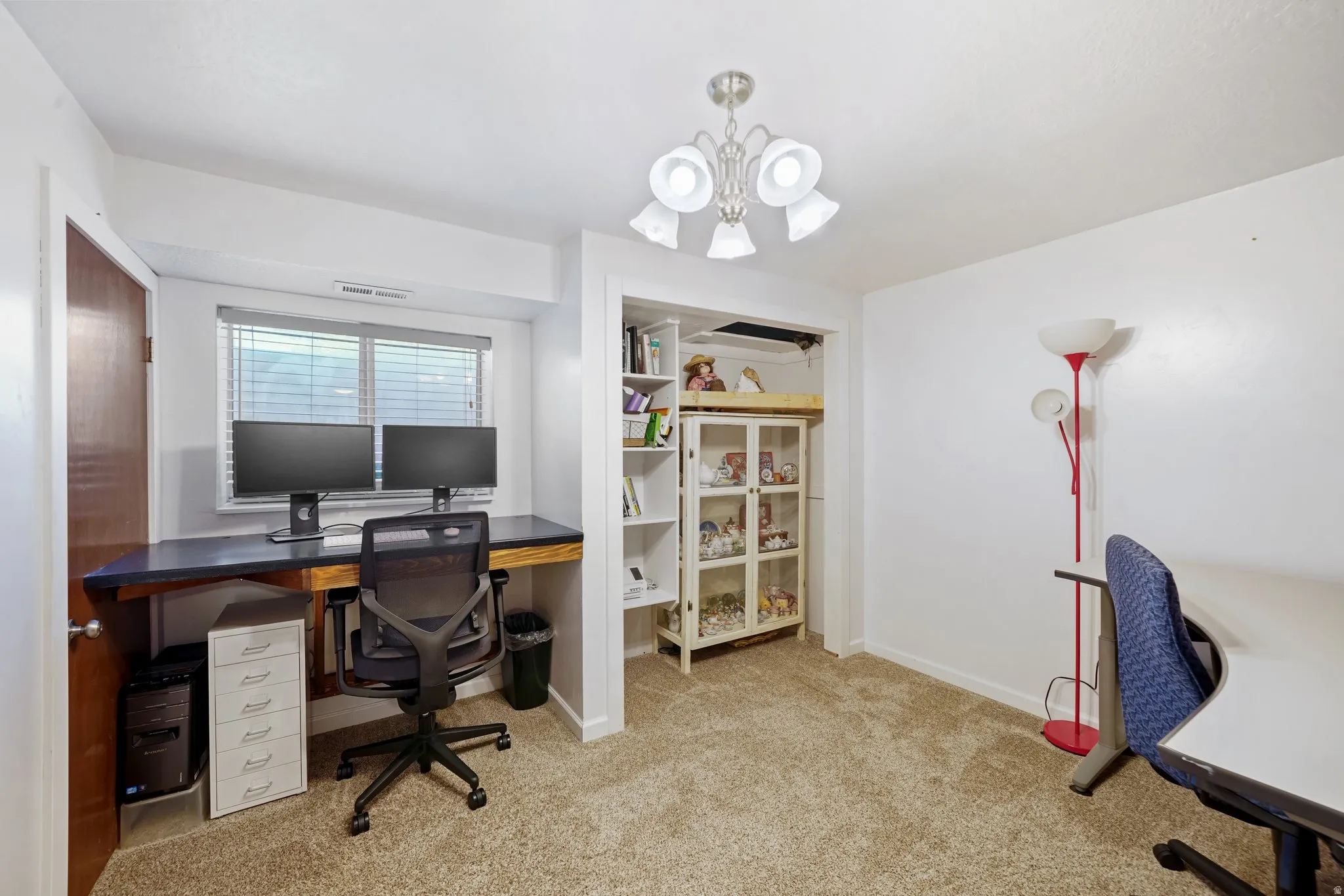 Office space featuring light colored carpet and a chandelier