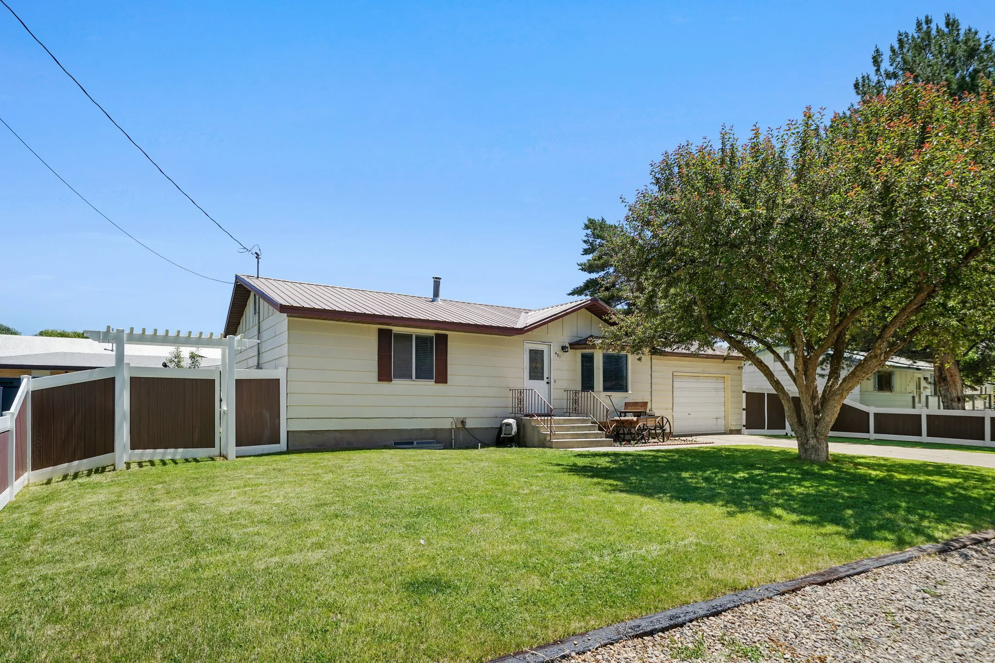 View of front of house featuring a metal roof, a garage, driveway, crawl space, and a gate