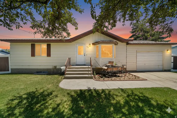 Single story home with an attached garage, a front yard, and concrete driveway