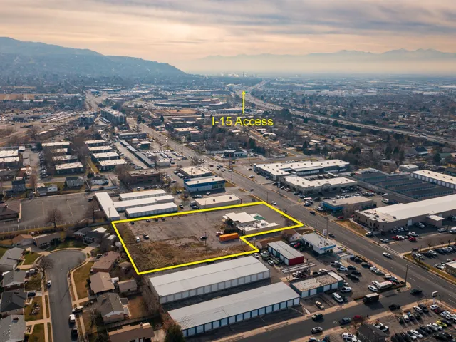 Aerial view of property and surrounding area with property parcel outlined and an industrial area