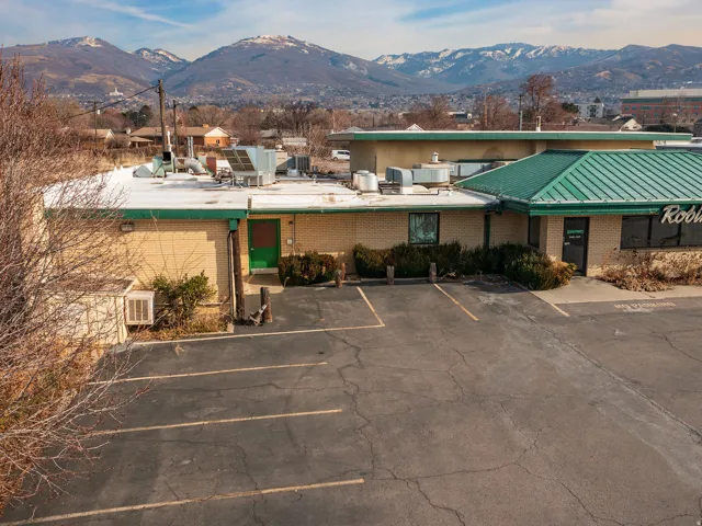 View of building exterior with a mountain view and uncovered parking