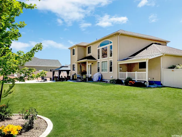Rear view of property with a gazebo, a patio area, and stucco siding