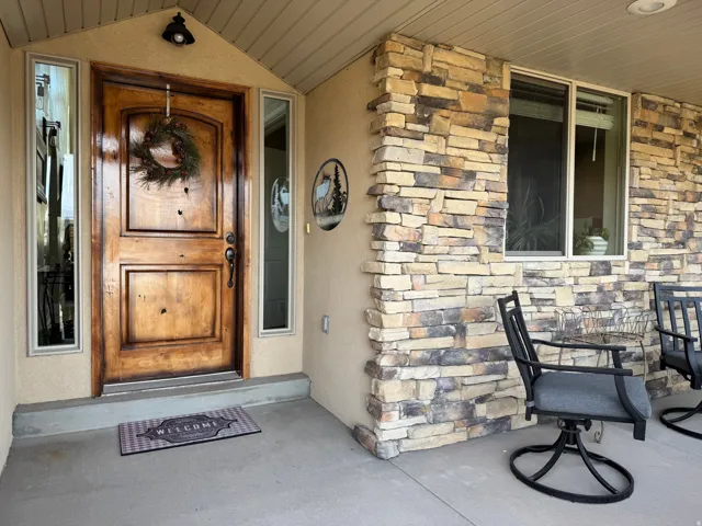 Entrance to property with stone siding and stucco siding