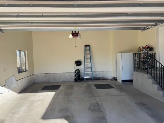 Garage with freestanding refrigerator and a garage door opener
