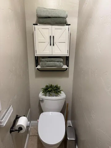 Bathroom featuring a textured wall and toilet