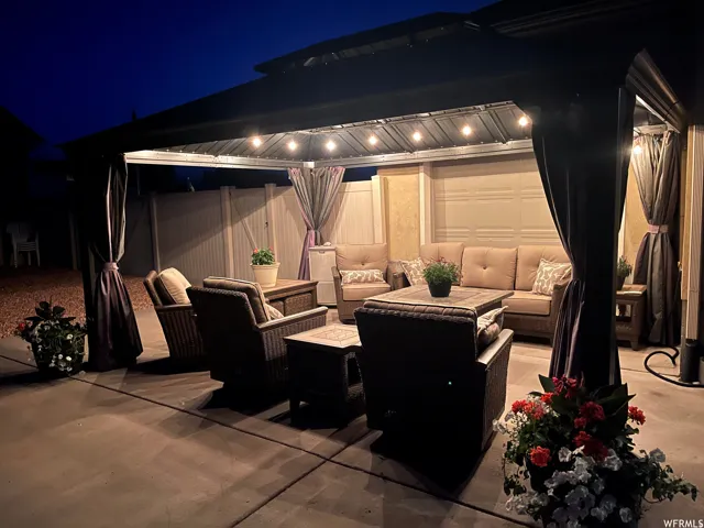 Patio at night with an outdoor living space and a patio area
