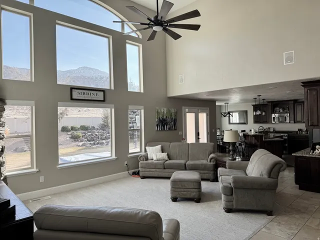Living area with a towering ceiling and ceiling fan