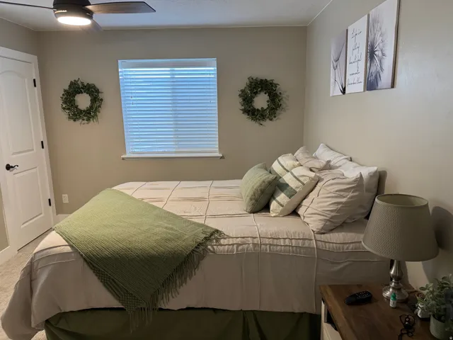 Carpeted bedroom with ceiling fan